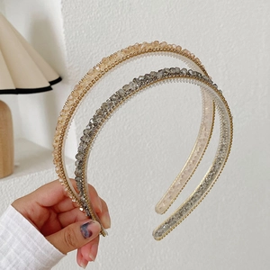 Detail of slim crystal headbands in champagne and grey colors with sparkling beads