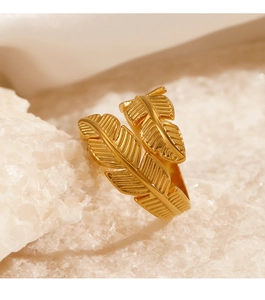 Macro detail of gold-plated stainless steel leaf ring on white mineral stone