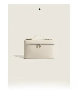 Detail of cream leather vanity bag with premium pebbled texture and metal double zippers