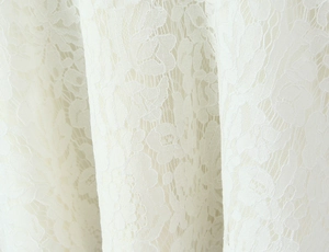 Détail macro de broderie en dentelle florale blanche avec texture ajourée délicate