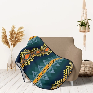 Detail of soft flannel throw blanket with tribal geometric patterns on a beige sofa