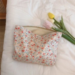 Detailed view of floral pattern cotton pouch with zipper on white fabric background