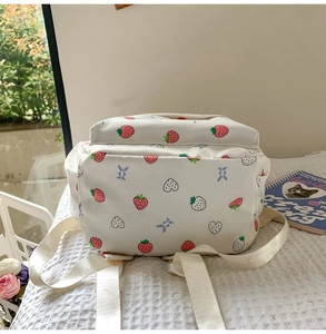 Close-up of white strawberry printed backpack with soft canvas texture and vivid details