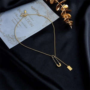 Minimalist gold chain necklace featuring safety pin pendant and Love engraved square tag