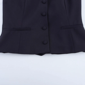 Detailed close-up of dark halter top vest showing fabric texture and fabric-covered buttons