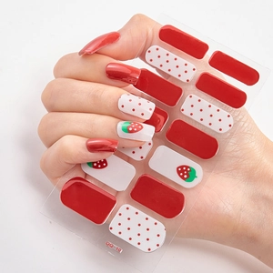 Adhesive strawberry and red polka dot nail art stickers shown on a model hand