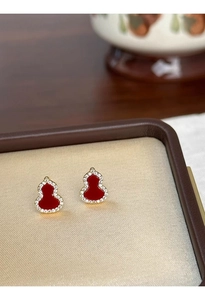 Macro shot of red gourd stud earrings with gold plating and sparkling zircon stones