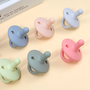 Set of six macaron-colored silicone baby pacifiers and teething toys with textured handles