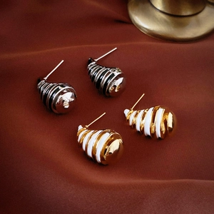 Elegant gold and silver conch shell stud earrings on luxurious red silk background