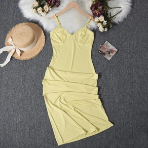 Abito midi giallo pallido aderente con cappello di paglia e accessori per le vacanze