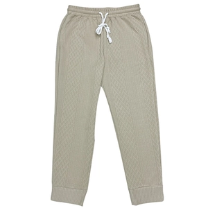 Detail view of khaki knit joggers featuring textured fabric and white drawstring waist