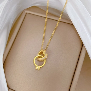 Elegante collana in titanio dorato con ciondoli a cuore e anello intrecciati e micro cristalli