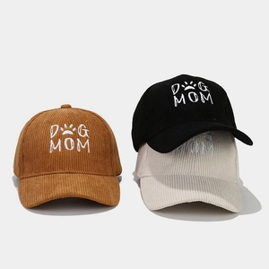 Detailed close-up of DOG MOM white embroidery on textured corduroy baseball caps