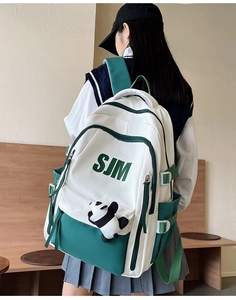 Retro student backpack in white and forest green with panda plush toy accessory