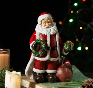 Festive Santa figurine with green wreath and gift box on a cozy holiday background