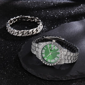 Macro view of iced-out silver watch with green dial and matching Cuban link bracelet