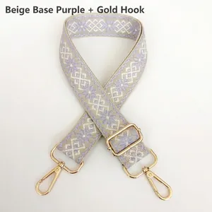 Close-up of beige and purple jacquard diamond pattern canvas strap with gold metal hooks