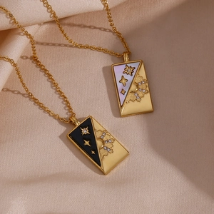 Macro detail of gold tarot necklaces with sun and star charms on satin silk fabric
