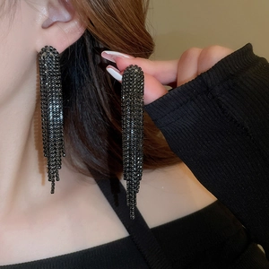 Close-up of black rhinestone tassel earrings showing length and craftsmanship on a model