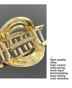 Close-up of golden hair claw clip featuring high carbon steel spring and premium alloy