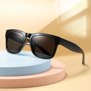 Classic black kids sunglasses with dark lenses on modern geometric display stand