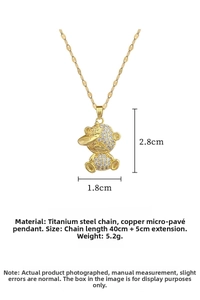 Macro shot of gold-plated cartoon bear pendant with white cubic zirconia and chain details