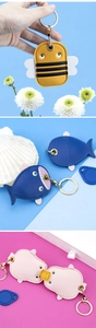 Close-up of animal leather card holders with gold keychains in bee and shark designs