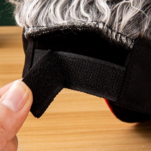 Close-up of adjustable black velcro strap on the back of a wig hat with grey hair