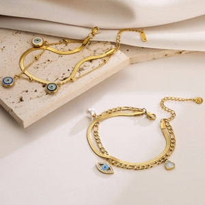 Double-layered gold evil eye bracelet with pearls and heart charms on silk and stone