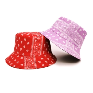 Close-up of red and purple paisley bucket hats showing stitched brim detail and cotton texture