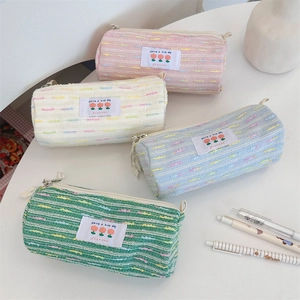 Detalle de estuches de tweed en tonos pastel con etiquetas tejidas y cierre suave