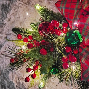 Detail of Christmas teardrop swag with LED lights, pine branches, berries, and plaid bow