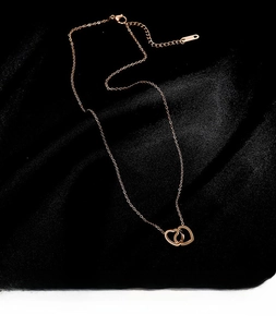 Close-up of interlocking double heart pendants on 18k rose gold minimalist chain