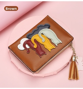 Detailed view of a brown zipper wallet with cat patchwork and stylish tassel charm