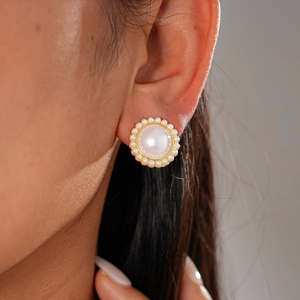 Gros plan d'une boucle d'oreille en perles de style baroque avec une base en métal doré