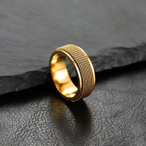 Macro detail of 8mm golden woven mesh texture on a punk style stainless steel ring