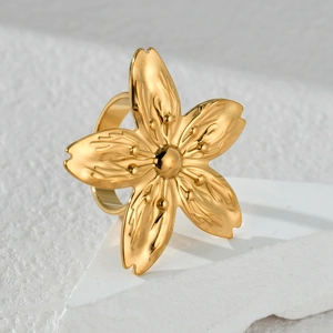 Macro detail of golden flower ring showing petal texture on a stone surface