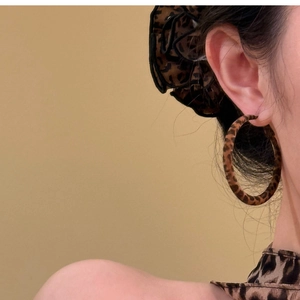 Vintage leopard print hoop earrings in warm brown finish on model for women