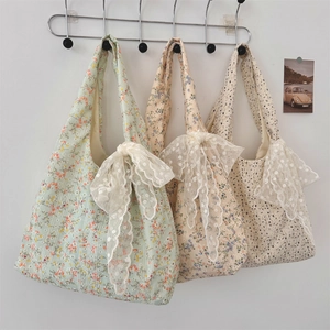 Detailed view of floral canvas tote bags with large white lace bows in vintage style