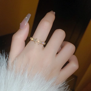 Macro view of gold-plated H-shaped ring with pavé zircons on model's finger