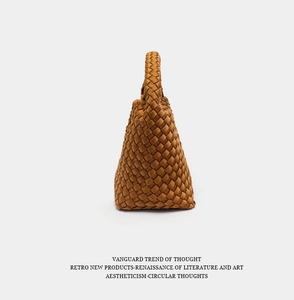 Detail of retro brown woven bucket bag showing intricate leather texture and top handle