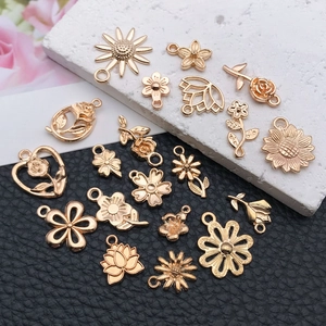 Golden flower pendants including sunflowers and roses on a black and white base