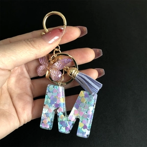 Resin letter M keychain with purple butterfly, tassel and colorful heart sequins