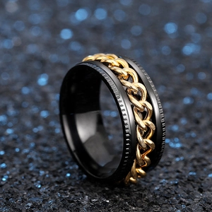 Macro shot of rotatable gold chain ring with black finish and textured metal edges
