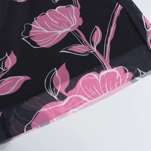 Close-up detail of black mesh fabric featuring pink floral print and fine stitching