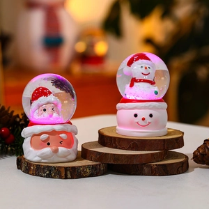 Luminous Christmas crystal balls with Santa Claus and Snowman figures on wood