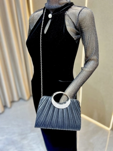 Silver pleated evening clutch with rhinestone handle shown on a mannequin with chain strap