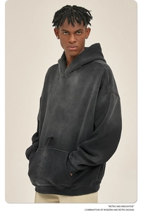 Detail van antraciet zwarte hoodie met distressed wassing en onafgewerkte randdetails