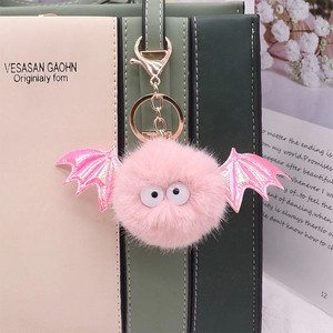 Pink faux mink fur bat keychain with glitter wings on a stylish handbag