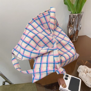 Detail of pink and blue checkered canvas tote bag with unique knot handle on table